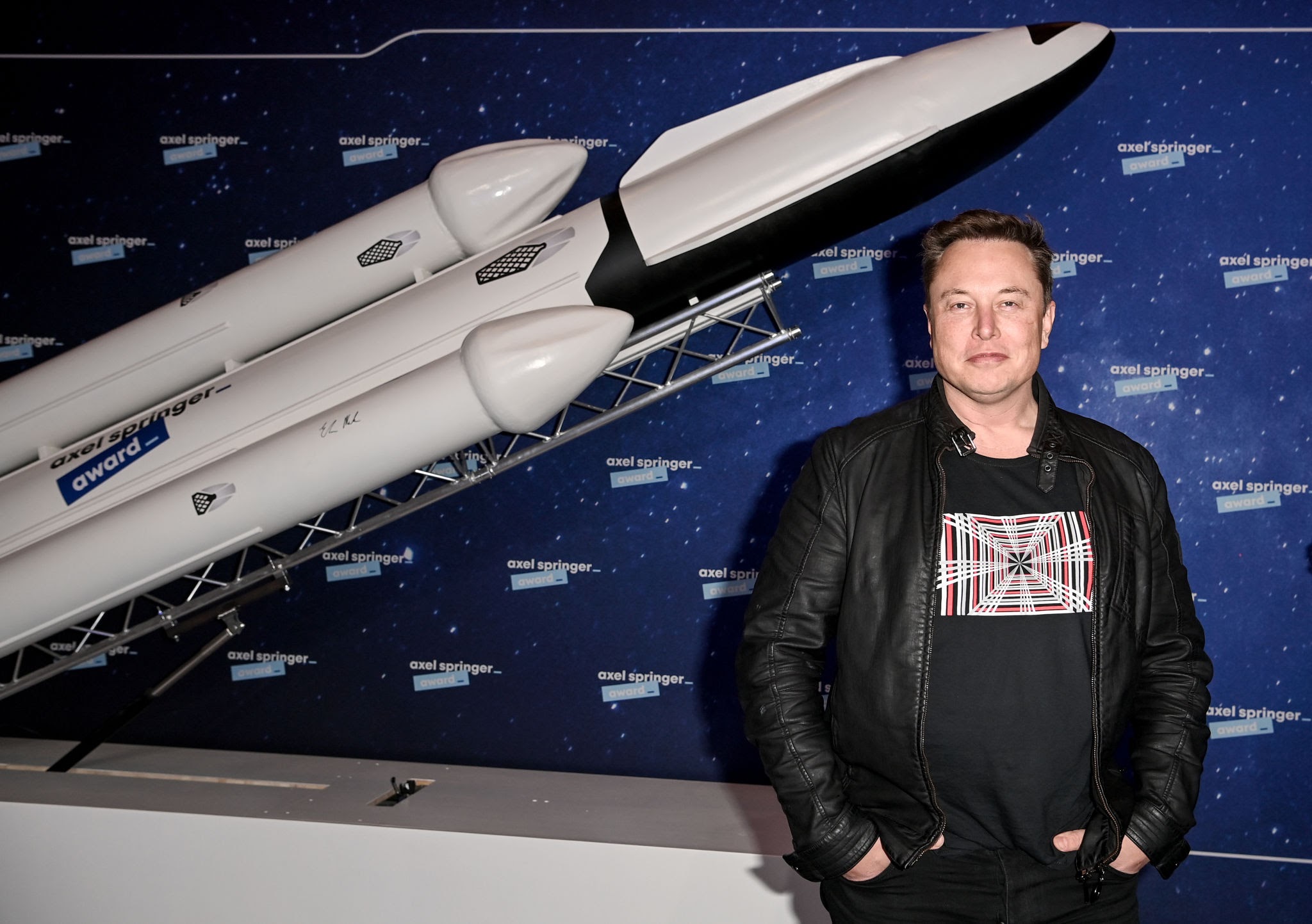 Musk frente a un modelo de cohete de SpaceX, generada por IA